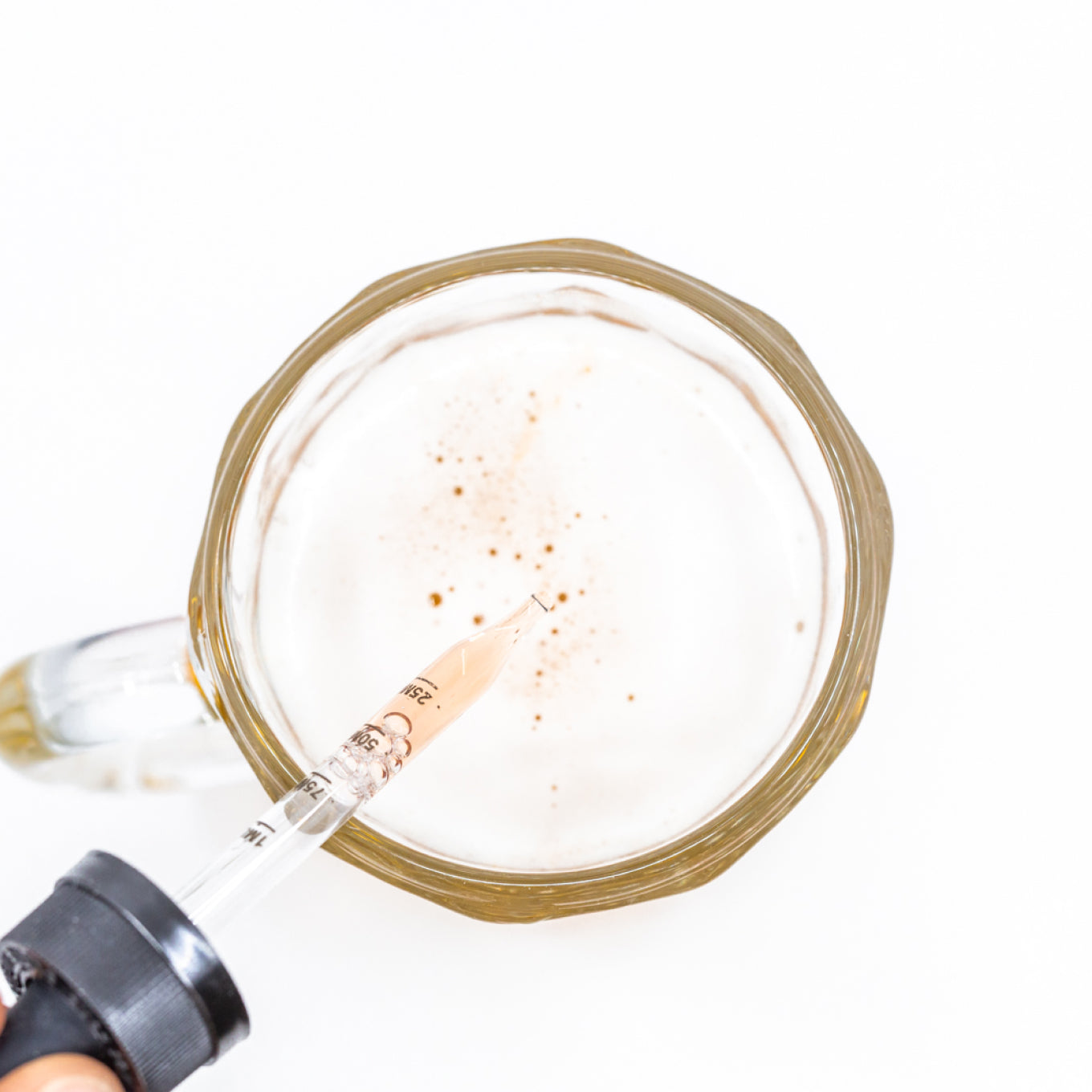 Birds eye view of a vial dropping into a stein of beer